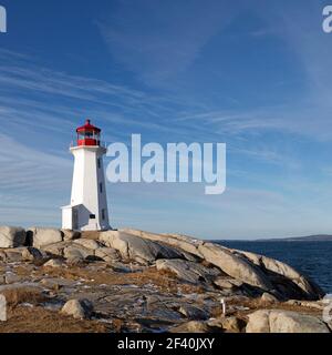 Faro di Peggys Point che si erge sulle rocce di Peggy's Cove a Nova Scotia, Canada. Il faro ottagonale fu costruito nel 1914. Foto Stock