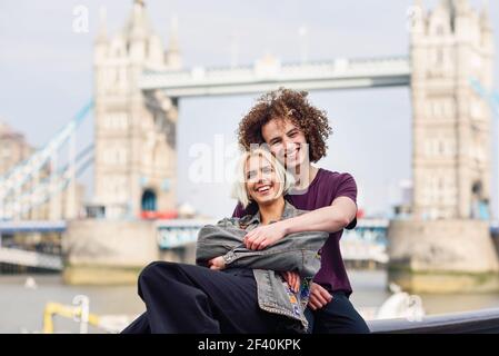 Felice coppia abbracciando al Tower Bridge, River Thames, Londra. REGNO UNITO. Felice coppia abbracciando al Tower Bridge Foto Stock