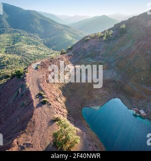 Vista aerea della miniera a cielo aperto abbandonata piena d'acqua sul monte Alestos, Cipro. Rocce rosse ricche di ferro e rame Foto Stock