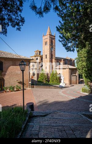 Antica chiesa Abbazia di Monte Oliveto maggiore con statua e strada. Asciano, Siena, Toscana, Italia, Europa. Foto Stock