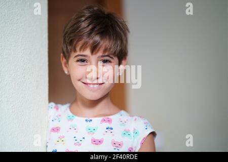 Bambina divertente, otto anni, fissando alla macchina fotografica sorridente a casa. Divertente bambina, otto anni, fissando sorridendo alla macchina fotografica. Foto Stock