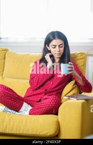 Donna persiana a casa con tè e lettura. Donna a casa con tè e lettura Foto Stock