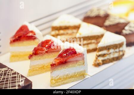 Torte assortite nella finestra di una panetteria. Torte nella finestra di una panetteria. Foto Stock