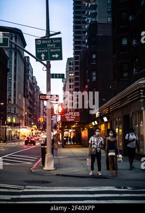 New York City, New York - 18 agosto 2020: Scena di strada da Manhattan in una serata estiva di persone in attesa di attraversare la strada indossando maschere durante Foto Stock