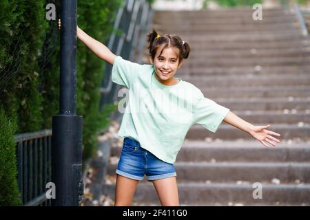 Ragazza di nove anni che gioca con una lampada da strada in un parco. Ragazza di nove anni che gioca con una lampada da strada Foto Stock