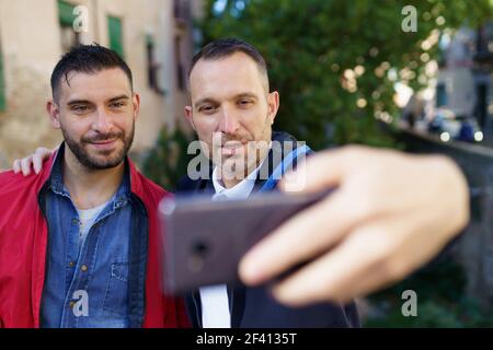 Coppia gay che fa un selfie con il loro smartphone. Concetto di relazione omosessuale.. Coppia gay che fa un selfie con il loro smartphone. Foto Stock