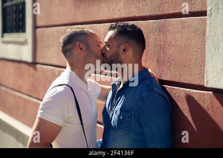 Coppia gay baciando all'aperto in ambiente urbano. Concetto di relazione omosessuale.. Coppia gay baciando all'aperto in ambiente urbano. Foto Stock