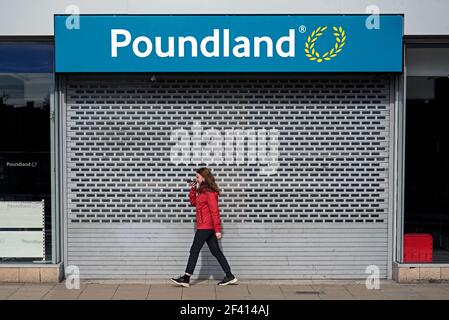 Giovane donna che cammina in un negozio di Shutterd Poundland su Princes Street, Edimburgo, Scozia, Regno Unito. Foto Stock