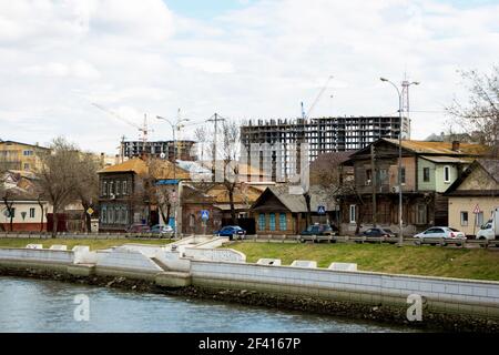 Astrakhan, Russia, 21 di marzo 2018: Molti vecchi edifici in legno di fronte al sito di sviluppo moderno.. Astrakhan, Russia, 21 marzo 2018: Molti vecchi edifici in legno di fronte al sito di sviluppo moderno Foto Stock