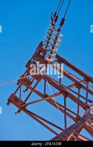 Isolatori ad alta tensione in fila sulla torre di alimentazione di fronte al cielo. Isolatori ad alta tensione in fila sulla torre di alimentazione Foto Stock