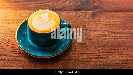 Tazza da caffè verde piena di supporti per cappuccino sul piano portapaziente, inage con un sacco di spazio per la copia. Tazzina da caffè di colore verde piena di supporti per cappuccino sul piano portapaziente Foto Stock