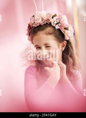 Adorabile ragazza carina con una corona di fiori colorati Foto Stock