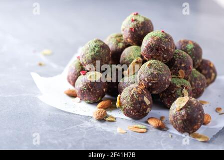 Palle di energia grezza con polvere di tè matcha su sfondo grigio. Verdure crude, dolci vegetariani. Senza zucchero, senza glutine, senza lattosio Foto Stock