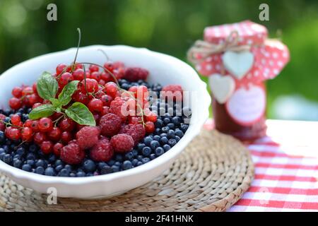 Frutti di bosco freschi e confettura di lamponi, servita nel giardino estivo Foto Stock