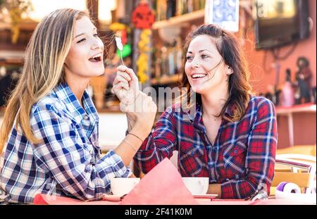 Girlfriends felice coppia bere cappuccino e ridere insieme - Hangout concetto con le giovani donne che parlano e che si divertono al caffè bar Foto Stock