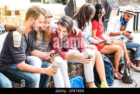 Gruppo di Millennial multirazziali che utilizza smartphone presso il cortile dell'università - giovani dipendenti da smartphone mobile - concetto di tecnologia Foto Stock