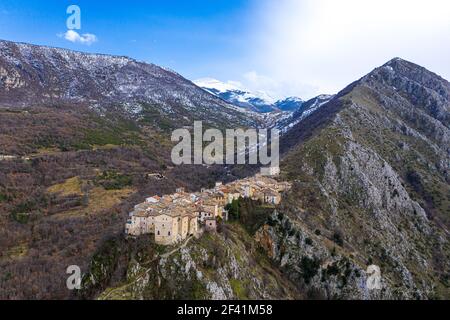 L'immagine di un drone rivela un'antica città arroccata su una vetta in Abruzzo, adornata da diversi edifici illuminati dalla splendida luce solare invernale Foto Stock