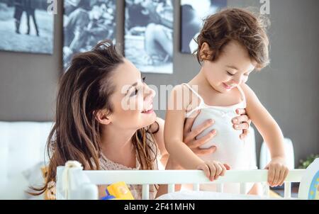 Allegro giovane madre abbracciando la sua diletta figlia Foto Stock