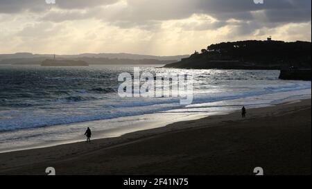 Vista costiera con 2 persone la Magdalena Penisola Mouro e faro Santander Cantabria Spagna paesaggio di inizio mattina inverno Foto Stock