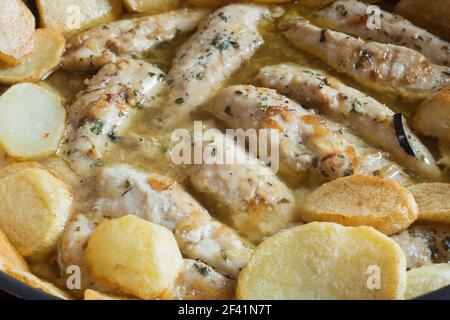 Ricetta di filetti di pollo con aglio e spezie in salsa verde accompagnata da patate al forno. Cibo fatto in casa. Foto Stock