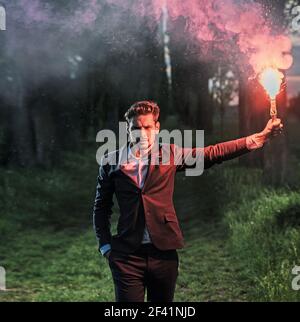 Ritratto concettuale di un ambizioso imprenditore tenendo un red flare Foto Stock