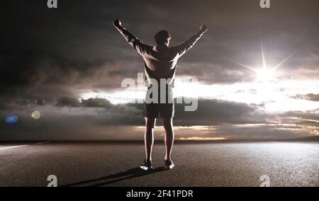 Ritratto di un atleta guardando il cielo scuro Foto Stock