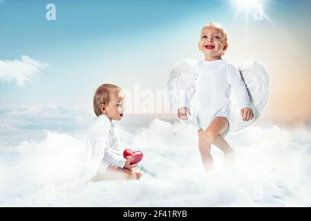 Ritratto concettuale di un allegro due amorini sul cloud Foto Stock