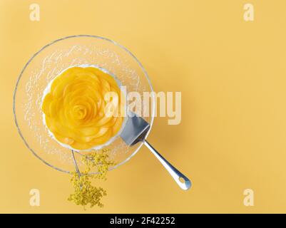 Dessert a tre latti decorato con pesche su sfondo giallo. Spazio di copia. Vista dall'alto. Foto Stock