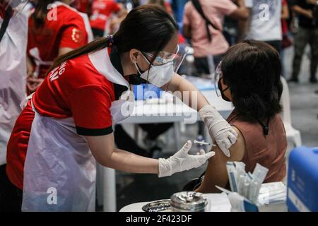 Un operatore sanitario inietta una dose del vaccino Sinovac durante un viaggio di vaccinazione a San Juan City, Metro Manila, Filippine. Foto Stock