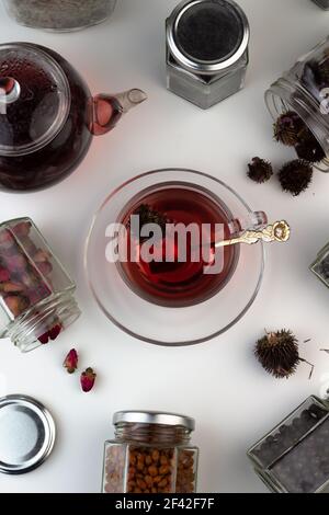 Tè alle erbe fatto in casa. Un rimedio che aumenta l'immunità e allevia lo stress. Teiera in vetro e tè con una bevanda sana. Vasi trasparenti con erbe secche Foto Stock