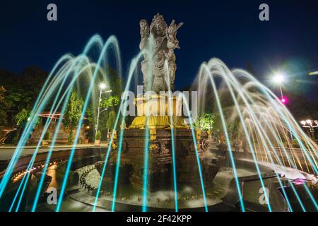 Vista notturna della statua e della fontana di Patung Catur Muka nel centro di Denpasar City, capitale di Bali, Indonesia. Foto Stock