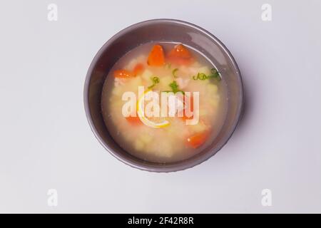 Zuppa cremosa con salmone in ciotola e fette di pane di segale su fondo grigio testurizzato, fuoco selettivo Foto Stock