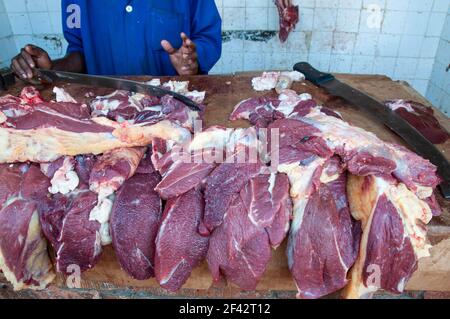 Un macellaio in Uganda vende carne al suo negozio all'aperto. Foto Stock