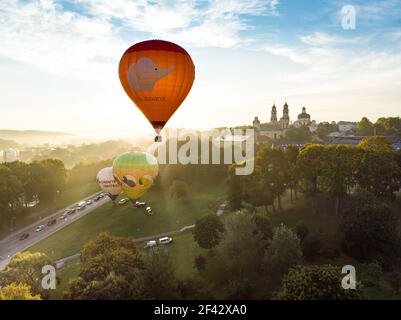 VILNIUS, LITUANIA - 20 AGOSTO 2020: Palloncini colorati ad aria calda che decolla nella città vecchia di Vilnius la mattina soleggiata estiva. Molta gente vigile Foto Stock