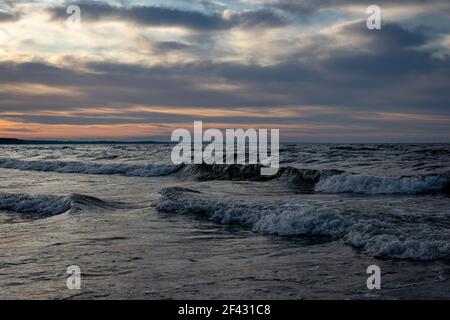 Bellissimo paesaggio nuvoloso dorato sul Mar Baltico, tramonto sparato. Foto Stock