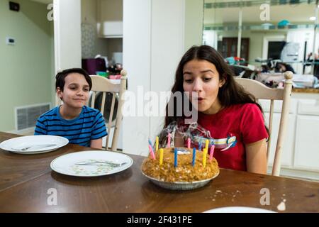 La ragazza teen soffia fuori le candele sulla torta di compleanno Foto Stock