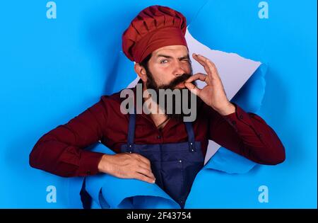 Chef in cappello e grembiule con segno perfetto. Lo chef professionista mostra il segno per Delicious. Foto Stock