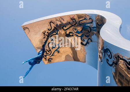 La parte superiore della forma d'onda di un acciaio inossidabile scultura di un onda di rottura in St Johns Square Blackpool Lancashire Inghilterra un diving figura è sulla parte superiore di esso Foto Stock