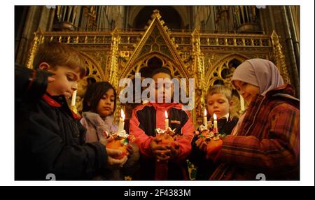 I bambini della St Barnaba Church of England School, Pimlico, si preparano a partecipare alle celebrazioni annuali di Christingle per i bambini della Childrens Societys presso l'abbazia di Westminster. Il tema di quest'anno è brillare una luce su BullyingLo arancione simboleggia il mondo, il nastro rosso il sangue di Cristo e la candela la luce del mondo. pic David Sandison 28/11/2002 Foto Stock