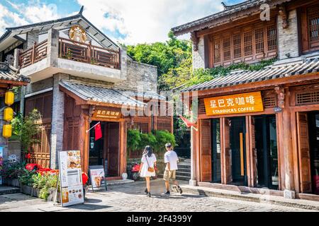 Dali China, 5 ottobre 2020: Caffetteria Starbucks con nome e logo in una vecchia casa cinese in legno e la gente asiatica che entra nel centro storico di Dali Y Foto Stock