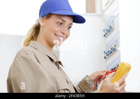 donna tecnico che legge la tensione di un misuratore fuseboad Foto Stock