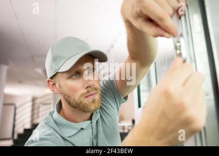 giovane uomo a mano con serratura a cambio uniforme Foto Stock