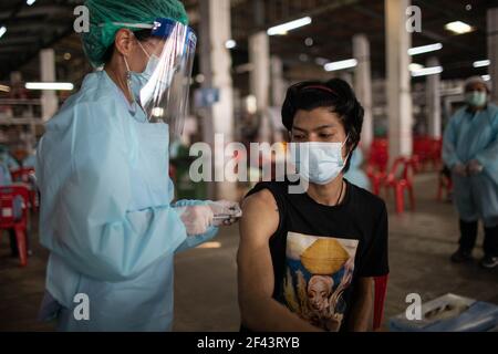 Bangkok, Thailandia. 18 Marzo 2021. Un operatore sanitario inocula un uomo con il vaccino CoronaVac (Sinovac) al mercato di Bang Khae durante un programma di vaccinazione di massa a Bangkok, Thailandia, il 18 marzo 2021. La Bangkok Metropolitan Administration (BMA) ha avviato un programma di vaccinazione di massa all'interno del mercato chiuso di Bang Khae dopo che 224 casi di Covid-19 sono stati trovati tra residenti in e intorno al mercato. Un totale di 6000 dosi saranno somministrate per i prossimi giorni ha detto il governatore. Credit: SOPA Images Limited/Alamy Live News Foto Stock