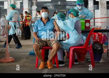 Bangkok, Thailandia. 18 Marzo 2021. Un operatore sanitario inocula un uomo con il vaccino CoronaVac (Sinovac) al mercato di Bang Khae durante un programma di vaccinazione di massa a Bangkok, Thailandia, il 18 marzo 2021. La Bangkok Metropolitan Administration (BMA) ha avviato un programma di vaccinazione di massa all'interno del mercato chiuso di Bang Khae dopo che 224 casi di Covid-19 sono stati trovati tra residenti in e intorno al mercato. Un totale di 6000 dosi saranno somministrate per i prossimi giorni ha detto il governatore. (Foto di Guillaume Payen/SOPA Images/Sipa USA) Credit: Sipa USA/Alamy Live News Foto Stock