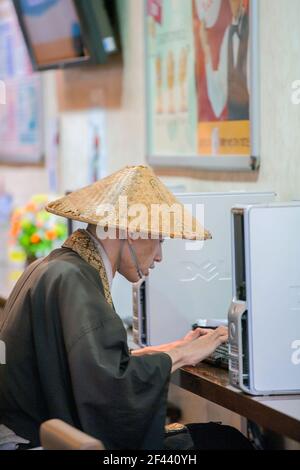 Monaco buddista giapponese che usa il computer nel bar Ginza, Tokyo, Giappone Foto Stock