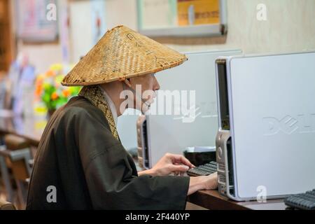 Monaco buddista giapponese che usa il computer nel bar Ginza, Tokyo, Giappone Foto Stock