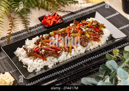 Maiale con verdure miste con sugo servito con riso. Cucina di stile Asiatico Foto Stock