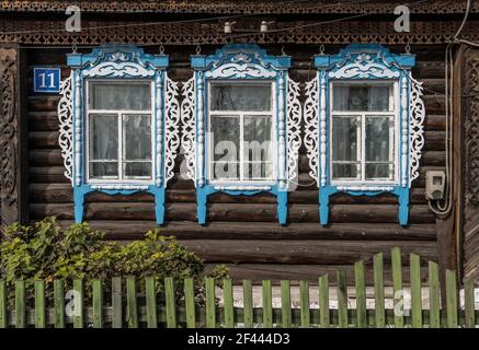 Vecchia cabina in legno russa con recinzione verde e finestre decorative a Krasnoyarsk, Siberia, Russia. Foto Stock
