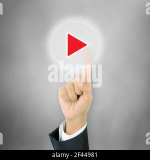Mano dell'uomo d'affari premendo il pulsante Play sullo schermo virtuale Foto Stock