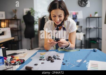 Designer professionista che sceglie i pulsanti per il panno blu Foto Stock